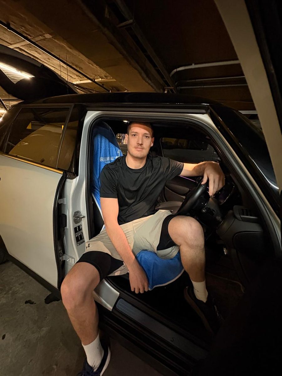 Frans, the founder, sitting in the driver's seat of his car in gym kit after training, on a Rawdog towel fitted over the seat.