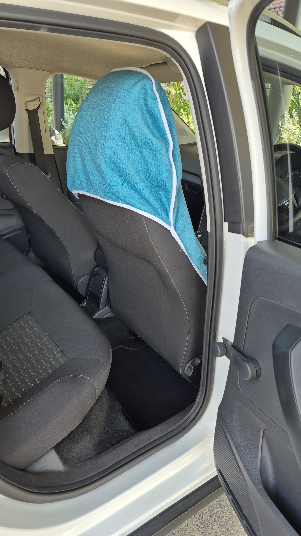 A Rawdog towel pulled down over a headrest, seen from the rear door.